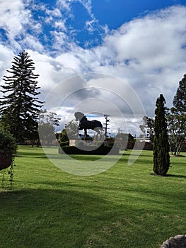 Horse sculpture with mountains and trees with blue sky photo