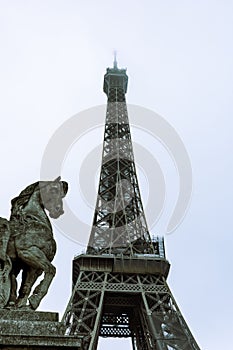 the horse statue is on top of the ledge in front of the eiffel