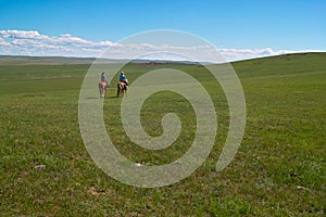 Horseback riders in grassland photo