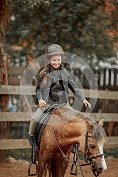 Horseback riding little girl on pony