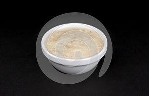 Horseradish sauce in bowl isolated on black background