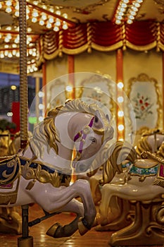 Horses to sit in a street festive carousel. Mass festivities and fun. Close-up.