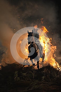Horses traversing the fire with their rider