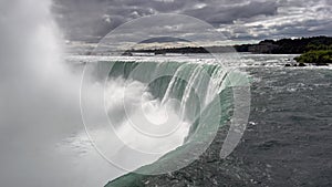 The horseshoe falls - part of Niagara Falls in Canada - close up of the upper edge, the falling water and the massive spume,