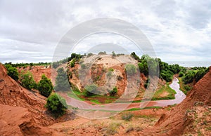 Horseshoe shaped stream running down a red canyon in Vietnam near Mui Ne