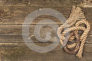 Horseshoe and vintage rope. Concept of good luck for St. Patrick`s Day. Old wooden boards background