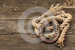 Horseshoe and vintage rope. Concept of good luck for St. Patrick`s Day. Old wooden boards background