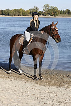 Horsewoman on horseback caressing horse photo
