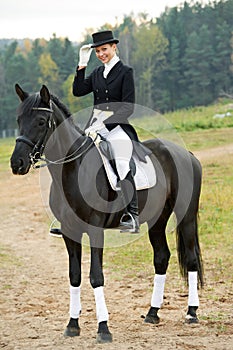 Horsewoman jockey in uniform with horse photo