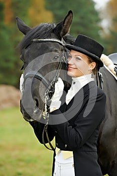 Horsewoman jockey in uniform with horse