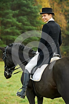 Horsewoman jockey in uniform with horse