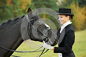 Horsewoman jockey in uniform with horse photo