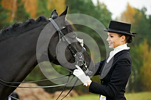 Horsewoman jockey in uniform with horse photo