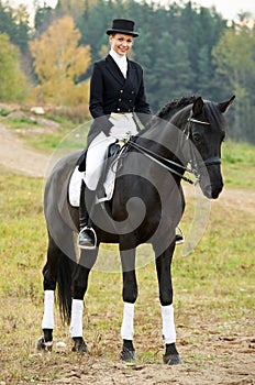 Horsewoman jockey in uniform with horse