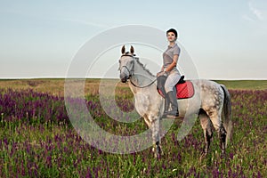 Horsewoman jockey in uniform riding horse outdoors