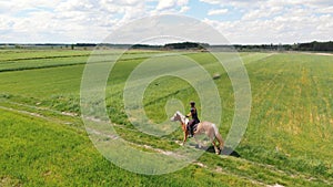 Horsewoman On A Palomino Horse Moving Across The Beautiful Farm Field -Cloudy Sky