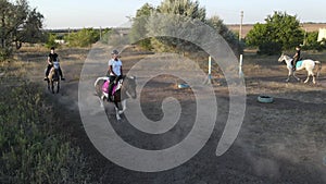 Horsewomen ride by trot horseback in paddock