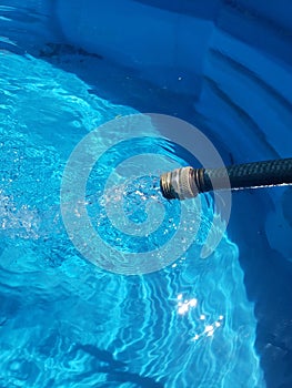 Hose filling up a pool with water
