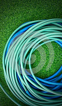 The hose watering plants on green artificial grass