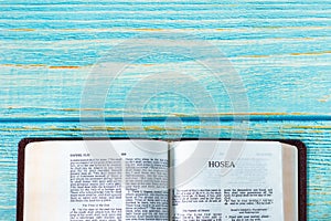 Hosea open Holy Bible Book on a rustic wooden background