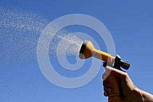 Hosepipe spraying water against on summer\'s day