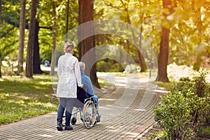 Nurse helping elderly man on wheelchair outdoor