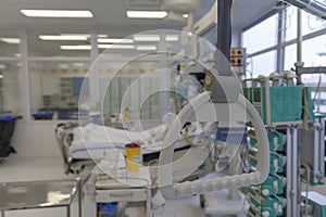 Hospital bed trapeze, on background patient  connected to medical ventilator in ICU in hospital, a place where can be treated