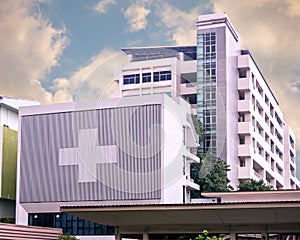 Hospital building with big symbolic at cloudy day