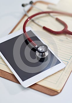 Hospital, clinic and tablet with stethoscope on desk for medical website, telehealth and research. Healthcare