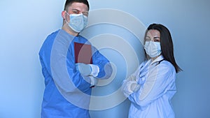 In the hospital clinic Two young doctors in lab coats a nurse and a doctor with a folder in their hands, scratching the synchron