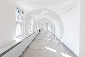 Hospital corridor bright light windows sun rays long white nobody