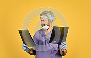 Hospital emergency. Surgeon estimate damages. Doctor uniform. X-ray concept. X ray radiation. The doctor holds pictures
