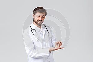 Hospital, healthcare workers, covid-19 treatment concept. Handsome bearded physician or doctor in white scrubs with