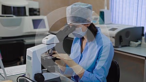 Hospital laboratory with equipment and microscope. Portrait of a half-cut female doctor or female student. The