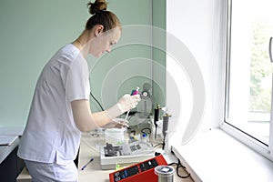 At a hospital laboratory. Lab technician performing analysis of blood samples with gas-electrolyte analyzer