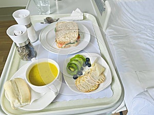 Hospital meal, breakfast including fruits and crackers, pumpkin soup and sandwich .