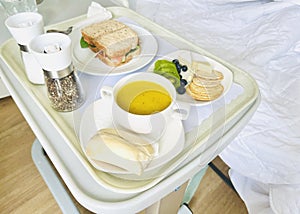 Hospital meal, breakfast including pumpkin soup sandwich fruits and crackers.