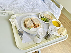 Hospital meal, breakfast including sandwich fruit cookie cracker and pumpkin soup.