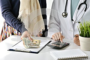 Hospital and medical expense, Doctor and woman patient calculate on disease treatment fee charges. photo