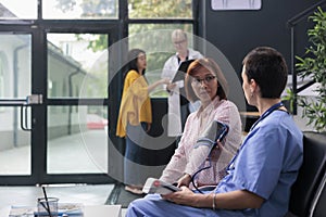 Hospital nurse doing cardiology exam with tonometer