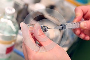 Hospital nurse fills a syringe medication