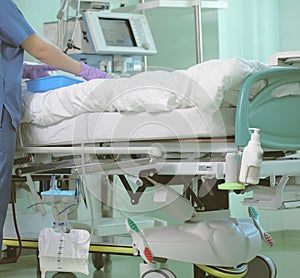 Hospital nurse at the patients bedside in intensive care