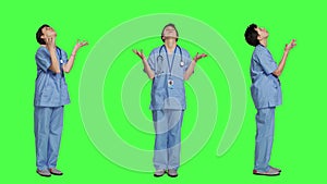 Hospital nurse worshipping God by prayer against greenscreen backdrop