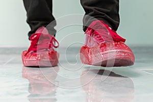 a hospital patient visitor walking in the shoe covers to protect hygiene on the floor