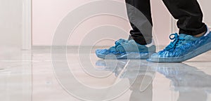 a hospital patient visitor walking in the shoe covers to protect hygiene on the floor