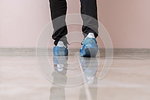 a hospital patient visitor walking in the shoe covers to protect hygiene on the floor