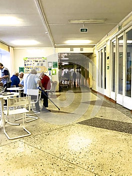 Hospital patients at lunch. They sit at the tables in the corridor of the clinic.