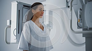 Hospital Radiology Room: Beautiful Multiethnic Woman Standing in Medical Gown in the X-Ray Machine