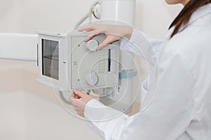 Hospital Radiology Room. Xray machine for fluorography. Doctor radiologist in gown adjusting the X-ray machine for