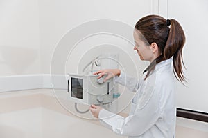 Hospital Radiology Room. Xray machine for fluorography. Doctor radiologist in gown adjusting the X-ray machine for